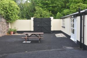 a picnic table in front of a building with a gate at The Village Bed and Breakfast in Cushendall