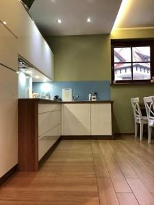 a kitchen with a counter and chairs in a room at Apartament Hania - Krynica Morska in Krynica Morska