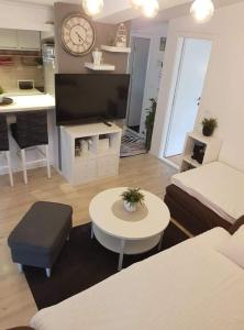a living room with a bed and a table and a clock at Apartment Silvija in Makarska