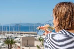 uma mulher a beber um copo de vinho com vista para um porto em Residence Marina Salivoli em Piombino