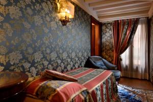 um quarto com uma cama e uma cadeira em Royal San Marco Hotel em Veneza