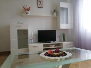 a living room with a tv and a glass table at Apartment Placido Krk in Krk