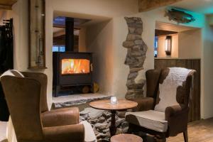 a living room with a fireplace and two chairs and a table at Barley Mow in Burnley