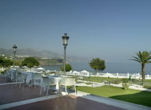 
a patio area with tables, chairs and umbrellas at Parador de Nerja in Nerja
