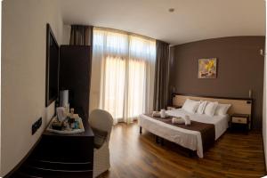 una camera d'albergo con un letto e una grande finestra di Hotel Carignano a Lucca