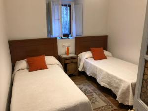 due letti in una piccola stanza con una finestra di El Requexu de Rales a Rales