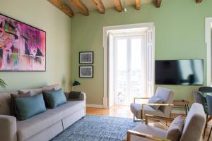 uma sala de estar com um sofá e uma televisão em Lisbon Panoramic View -3Bedrs+3Baths+ Balconies+AC em Lisboa