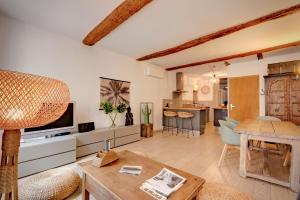 a living room with a television and a table at Le ST Tropez in Saint-Tropez