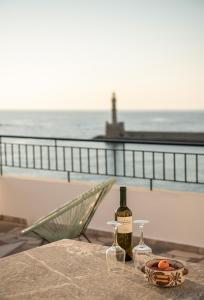 ハニア・タウンにあるAmphitrite Hotelのビーチのそばのテーブルに置かれたワイン1本とグラス1杯