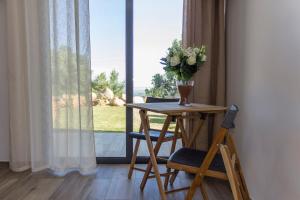 a table with a vase of flowers on it next to a window at Casa ATMAN in Monchique