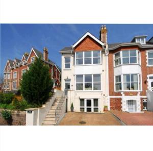 a large house with a staircase in front of it at High gables Apartment 1 in Paignton