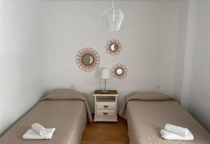 duas camas num quarto com espelhos na parede em Center Holiday Corralejo 2 em Corralejo