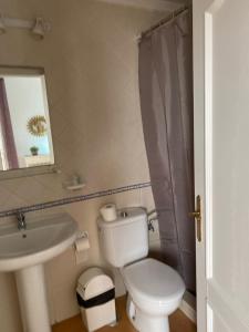 łazienka z białą toaletą i umywalką w obiekcie Center Holiday Corralejo 2 w Corralejo