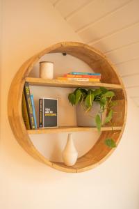 a circular wooden shelf with books and a plant at Forty Winks Loch Lomond in Balloch