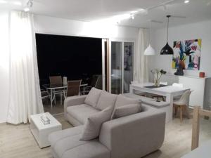 a white living room with a couch and a table at Nera's view in Ancient Epidauros