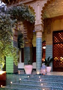 a building with two large vases on a patio at The Red House in Marrakesh