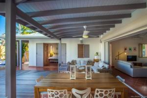 a dining room and living room with a table and chairs at Villa Laucaly Orient Bay in Saint Martin