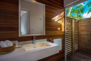 a bathroom with a sink and a mirror at Villa Laucaly Orient Bay in Saint Martin