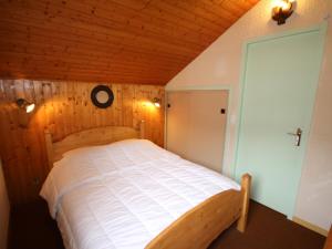 レ・セジーにあるAppartement Les Saisies, 3 pièces, 6 personnes - FR-1-293-233の木製の部屋にベッド1台が備わるベッドルーム1室があります。