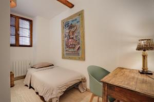 Un dormitorio con una cama, un escritorio y una mesa. en Le ST Tropez, en Saint-Tropez