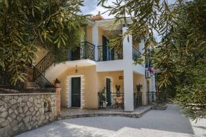 a house with black balconies and trees at Keri Marathias Pavezzo Villa in Marathias