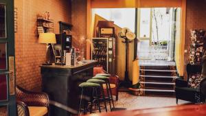 a bar with stools in a room with a window at Grand Hotel De La Poste - Lyon Sud - Vienne in Vienne