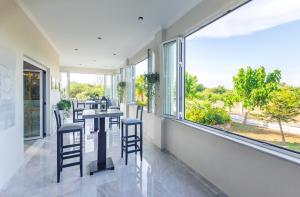 een kamer met een tafel, stoelen en ramen bij Erofili Hotel in Kavos