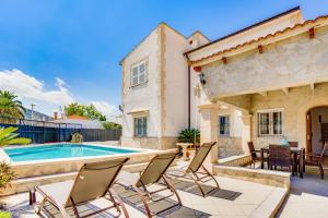 un patio avec des chaises et une piscine dans l'établissement Villa SANFORA Alcudia, à Port d'Alcúdia