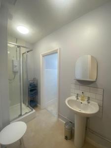 a white bathroom with a sink and a shower at Coastal Corner in Mundesley