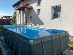 a large blue swimming pool next to a house at Villa Goldlux in Bihać
