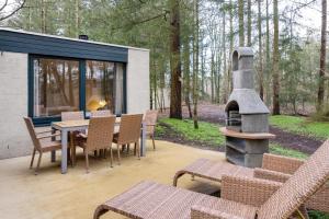 a patio with a table and chairs and a fireplace at Center Parcs Heijderbos Limburg-Weeze in Heijen