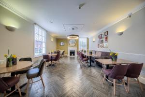 un restaurant avec des tables, des chaises et une cheminée dans l'établissement Grosvenor Hotel, à Stratford-upon-Avon