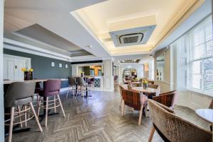 a dining room with tables and chairs and a room at Grosvenor Hotel in Stratford-upon-Avon