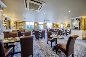 een restaurant met tafels en stoelen in een kamer bij Grosvenor Hotel in Stratford-upon-Avon