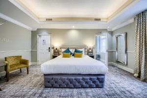 a bedroom with a large bed and a chair at Grosvenor Hotel in Stratford-upon-Avon +94 photos