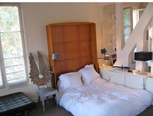 a bedroom with a large bed with a wooden headboard at duplex top central Marais in Paris
