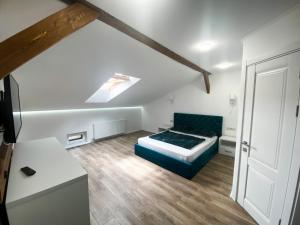 1 dormitorio con 1 cama azul en una habitación en Мансардні апартаменти в центрі міста en Ivano-Frankivsk