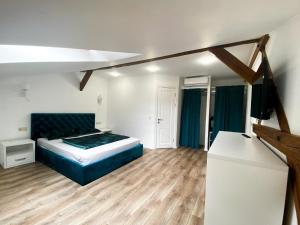 1 dormitorio con 1 cama y TV. en Мансардні апартаменти в центрі міста en Ivano-Frankivsk