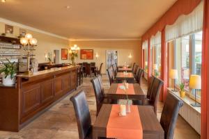 a restaurant with wooden tables and chairs and a bar at Park-Hotel Traben-Trarbach in Traben-Trarbach