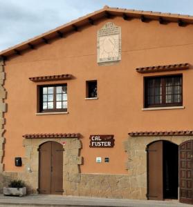 un edificio con un reloj al costado. en Casa rural Cal Fuster Experience, en Terrades