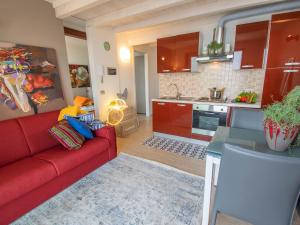 a living room with a red couch and a kitchen at Van Gogh - beautiful lake Iseo view and swimming pool in Parzanica