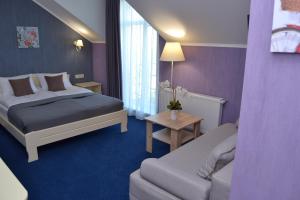 a hotel room with a bed and a couch at Hotel Ajur in Odesa