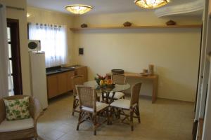 a kitchen and dining room with a table and chairs at CostaSol Pipa Chalés in Pipa
