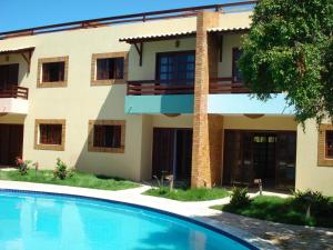 a building with a swimming pool in front of it at CostaSol Pipa Chalés in Pipa