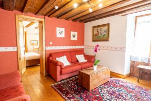 a living room with a red couch and a table at Hotel à l'Oriel in Riquewihr