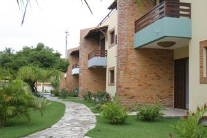 a brick building with a balcony on the side of it at CostaSol Pipa Chalés in Pipa