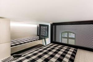 Pokój z 2 łóżkami piętrowymi i podłogą wyłożoną szachownicą w obiekcie Lofty Kampus Garnizon w Gdańsku