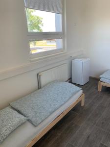 Bett in einem Zimmer mit einem Fenster und einem Bett sidx sidx sidx sidx in der Unterkunft Ubytování Litoměřická s parkovištěm in Česká Lípa
