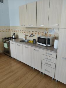 a kitchen with white cabinets and a microwave at Pokoje do wynajęcia in Częstochowa