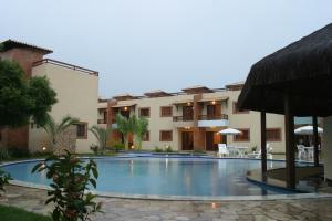 a swimming pool in front of a building at CostaSol Pipa Chalés in Pipa
